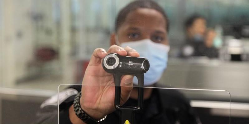 A U.S. Customs and Border Protection Officer at Dulles International Airport in Virginia holds up a camera used for facial biometric process. The agency is deploying biometric identity solutions to six more international airports in the southern United States. Credit: CBP