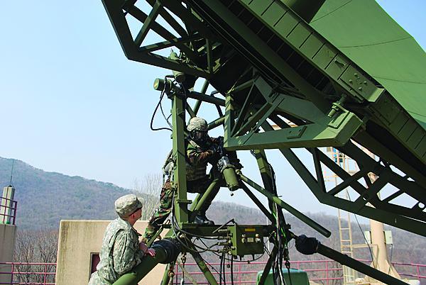 U.S. Army personnel work on a communications antenna in Korea. The 1st Signal Brigade is upgrading its communications infrastructure concurrent with a force transformation amid the continued threat of hostilities from North Korea.
