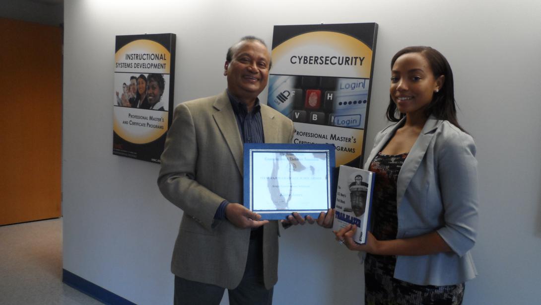 Mansur Hasib, chair of the graduate cybersecurity technology program at the University of Maryland, Baltimore County, presents the 2015 AFCEA STEM Major Scholarship for Diversity Students to Kiara Jones, a graduate.