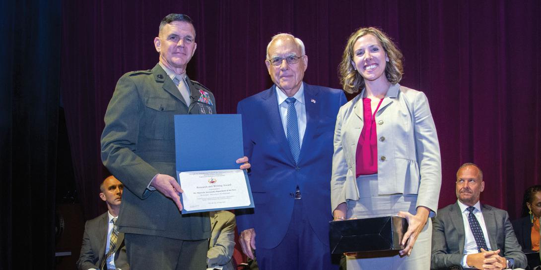 Lt. Gen. Otto Guenther, USA (Ret.) (c), presents the AFCEA “Sparky” Baird Award for Research Excellence in June to Maura K. Styczynski for her paper “Blockchain: Buzzword or Breakthrough” at the Dwight D. Eisenhower School for National Security and Resource Strategy alongside the school’s commandant, Maj. Gen. John Jansen, USMC.