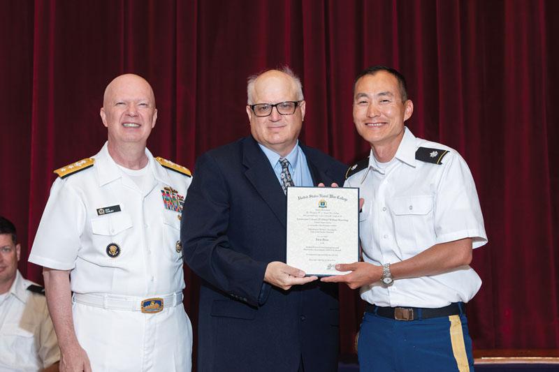 U.S. Naval War College President Rear Adm. Jeffrey Harley, USN (l), and Timothy Cathcart, executive vice president of the AFCEA Southern New England Chapter (c), present the AFCEA Research Honor Award in information operations/information warfare/command and control warfare (IO/IW/C2W) in June to Lt. Col. Daniel Rueckling, USA (r), for his paper “Information Warfare: Turning the Tide in the South China Sea” at the U.S. Naval War College.