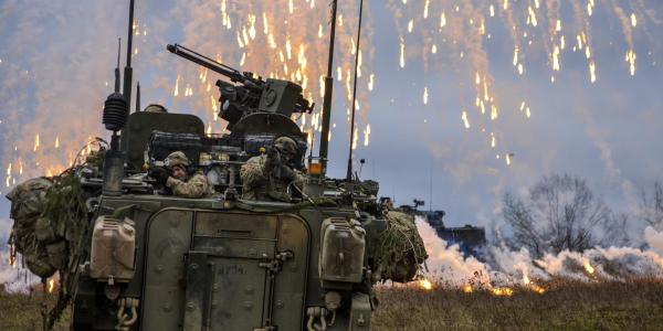 Soldiers attack simulated enemy combatants during a training exercise in Germany. Army researchers are integrating voice recognition into computing systems mounted onto vehicles with intercoms that allow soldiers to communicate in combat conditions.