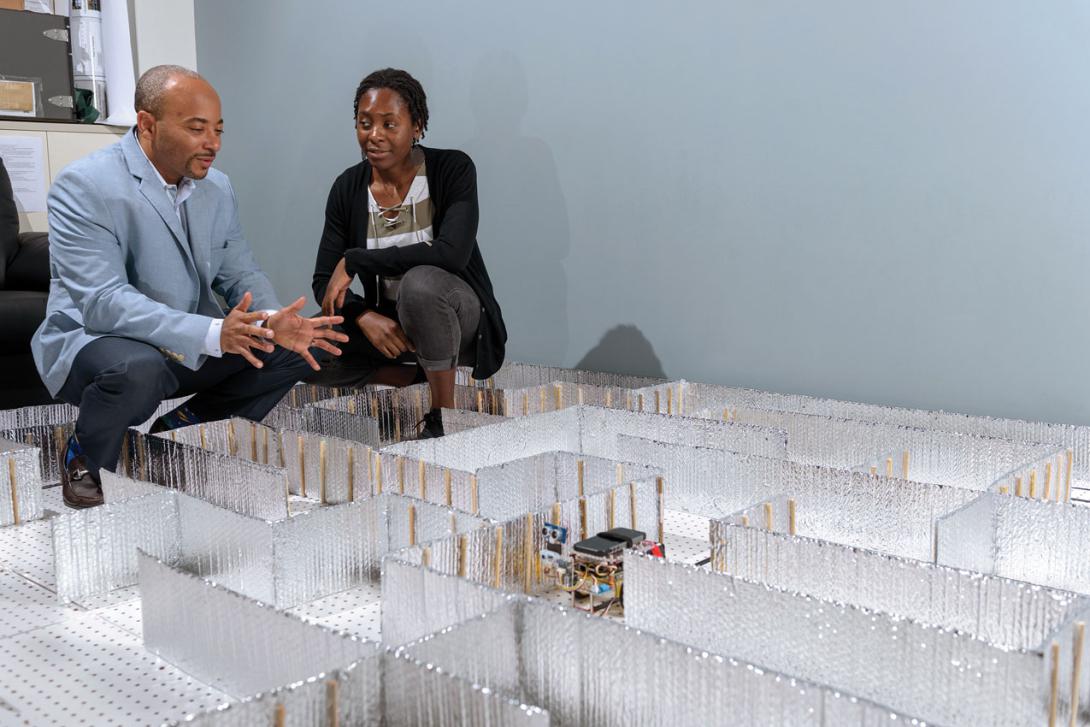 Raheem Beyah, the Motorola Foundation professor in Georgia Tech’s School of Electrical and Computer Engineering, and Celine Irvene, a student at Georgia Tech, watch the HoneyBot progress through a maze. Credit: Rob Felt