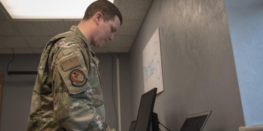 Staff Sgt. Jonathan Witzel, USAF, inspects a customer's laptop on Barksdale Air Force Base, Louisiana on March 20. With the COVID-19 pandemic forcing many Defense Department personnel to work from home, the Defense Information Systems Agency is seeing increased demand for its Cloud-Based Internet Isolation technology. U.S. Air Force photo by Tech. Sgt. Daniel Martinez