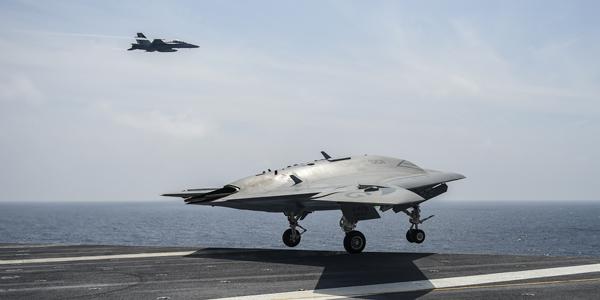 The X-47B unmanned air vehicle takes off from the deck of an aircraft carrier. The U.S. Navy recently conducted the fifth series of at-sea tests, proving that a manned and unmanned aircraft can maintain a takeoff and landing pattern aboard an aircraft carrier.