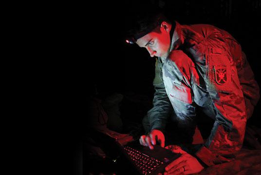 A U.S. Army John F. Kennedy Special Warfare Center and School student uses a PDA-184 computer during nighttime antenna training at Fort Bragg, North Carolina. The training qualifies students in the high frequency communications module to be proficient in making, installing, operating and maintaining short-, medium- and long-range antennas to communicate at long distances. Credit: K. Kassens
