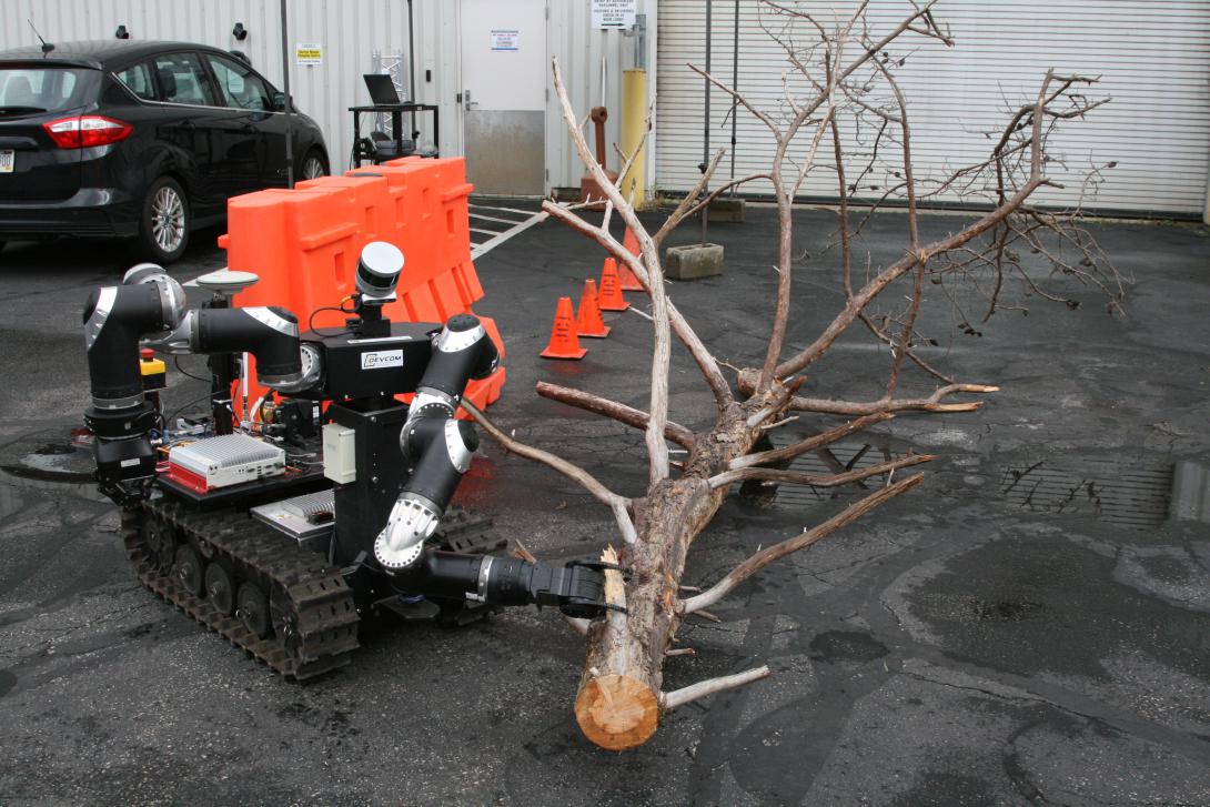 An ARL RCTA robot designed to clear paths of obstacles opted to use its clawed arm to drag a large tree limb out of the way rather than attempt to carry it off. Sensors weighed options based on the vehicle’s capabilities to determine the best course of action.