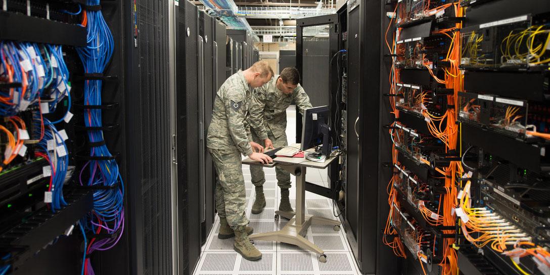 Tech. Sgt. David Mooers (l) and Senior Airman Mario Lunato, 2nd System Operations Squadron system administrators, access one of the core servers in the 557th Weather Wing enterprise at Offutt Air Force Base, Nebraska. The wing is employing specialized cybersecurity crews on top of other cyber defenses to protect weather intelligence. U.S. Air Force photo by Paul Shirk