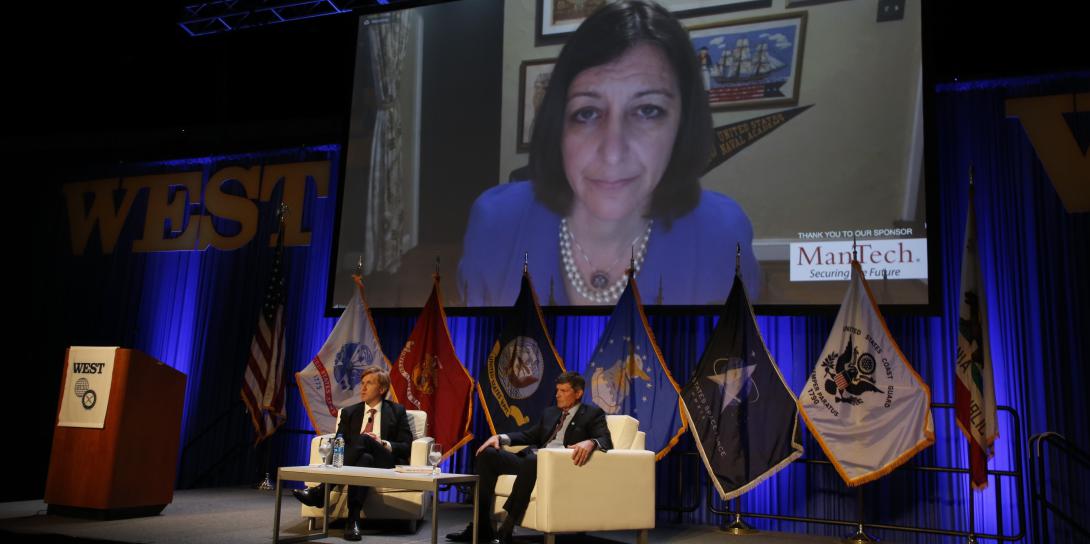 Rep. Elaine Luria (D-VA) appears on a video screen above fellow panelist Elbridge A. Colby (l), co-founder and principal, the Marathon Initiative, and panel host Adm. William F. Moran, USN (Ret.), former vice chief of naval operations, in the opening session of day 2 at WEST 2022 in San Diego. Photo by Michael Carpenter
