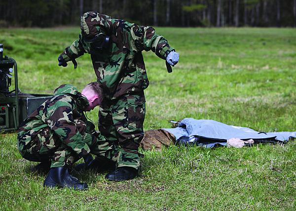 Marines at Camp Lejeune, North Carolina, assist each other in donning chemical and biological protection suits. Scientists are working to develop new fabrics that will minimize the need for the heavy, uncomfortable suits.  