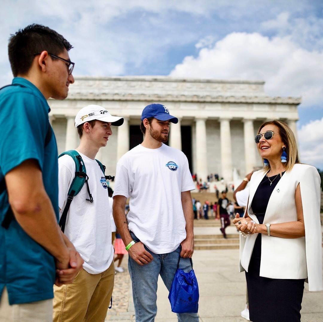 Dr. Irma Becerra, president, Marymount University (r), chats with students in front of the Lincoln Memorial during a fall orientation event in August 2018.  Photo by Marymount University