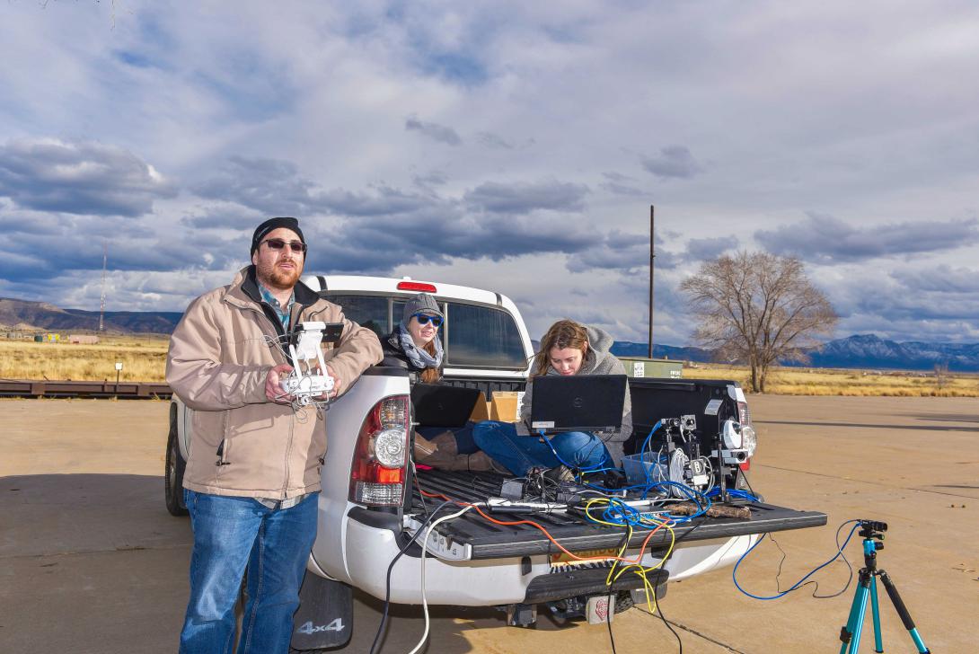 Camron Kouhestani (l) flies an unmanned aircraft system while Jaclynn Stubbs (c) and Bryana Woo monitor a camera stream at Sandia National Laboratories. Ground-based computer systems control the swarming drone platforms totrack and capture enemy aircraft systems while they fly. Photo by Randy Montoya