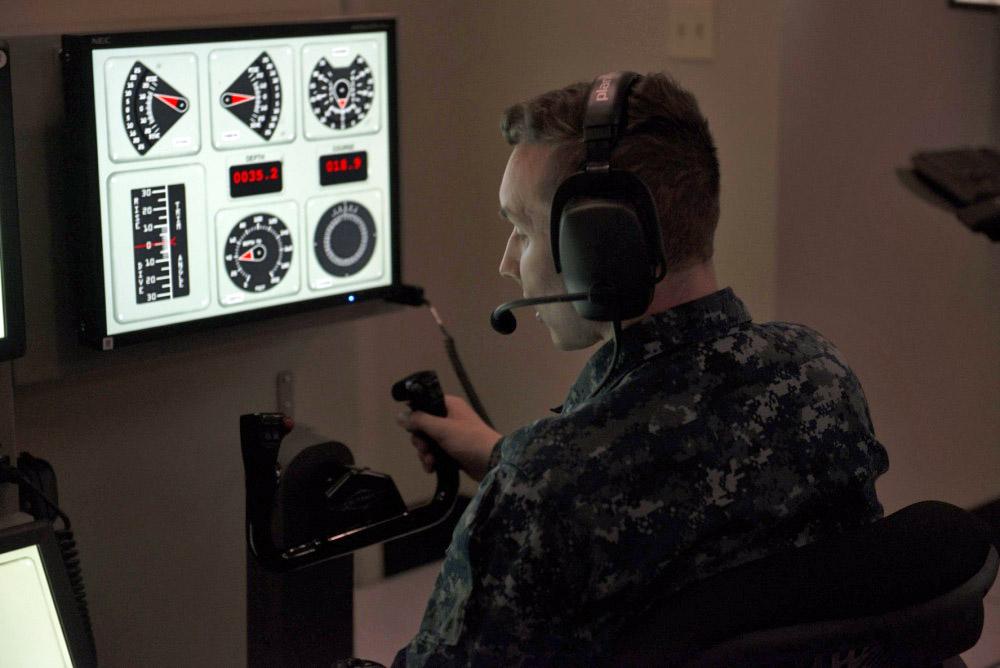 Machinist's Mate 3rd Class Tyler Rowell, USN, mans the helm in the attack center of the new submarine bridge trainer (SBT) at Trident Training Facility Bangor in Washington. Sailors assigned to USS Ohio Gold Crew participated in team training exercises in the trainer prior to the ribbon cutting and official opening.