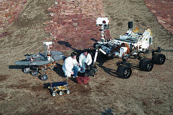 Three generations of Mars rovers developed at NASA’s Jet Propulsion Laboratory in California pose with spacecraft engineers at JPL’s Mars Yard testing area.   (photo credit: NASA JPL-Caltech)