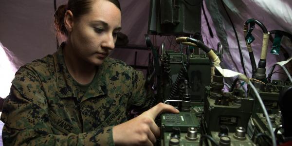 Sgt. April Vance, USMC, a field radio operator with Headquarters Regiment, 1st Marine Logistics Group, adjusts the communications network during a field training exercise at Camp Pendleton, California. Field radio operators employ a range of frequencies to establish communications, including ultrahigh frequencies, upper-very-high frequencies and high frequencies.  U.S. Marine Corps Photo by Staff Sgt. Rubin J. Tan, USMC