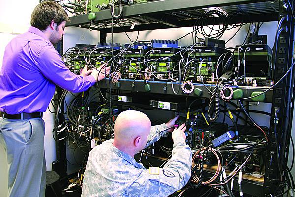 Engineers demonstrate live hardware, a radio in this case, being emulated and tested in a lab setting while the adjoining image shows a drawing of the radio used in the field.