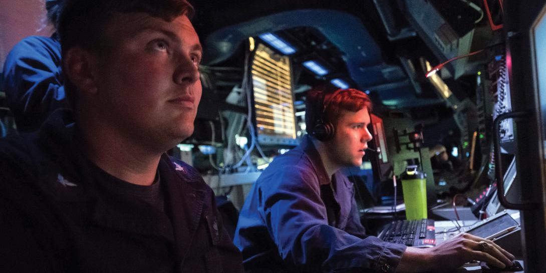 Two U.S. Navy sailors monitor data onboard the USS Jason Dunham during a 6th Fleet area operation. The Naval Information Forces command is consolidating information warfare activities and training to standardize all aspects of the domain across the Navy. U.S. Navy photo