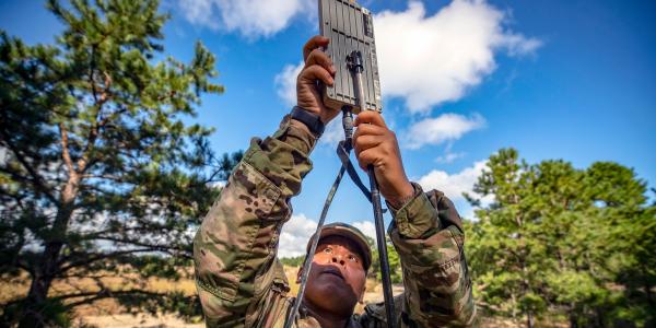 A U.S. Army soldier sets up an antenna during an unmanned aerial system training session. The Army may need to dial back on its data rate use if it is to employ effective battlefield communications networks, especially with new information technologies coming on line.