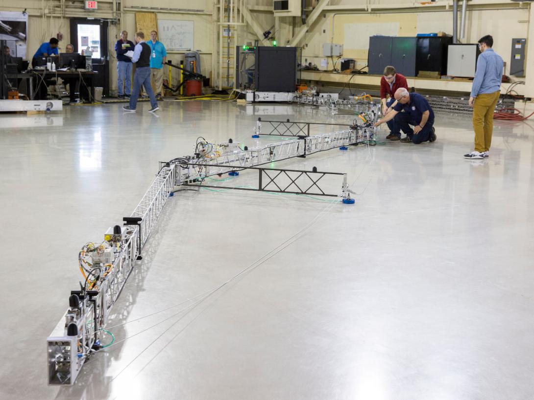Researchers at NASA Langley Research Center work on a robot arm known as Tension Activated Lightweight In-Space MANipulator, or TALISMAN. This device would provide a greater reach for servicing spacecraft in orbit.  NASA