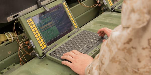 A U.S. Marine corporal at Camp Lejeune, North Carolina, works to set up a network so he and other Marines can share information via satellite. The Corps is working to ensure that capabilities Marines have in garrison can be taken to the field and operated seamlessly during a deployment.