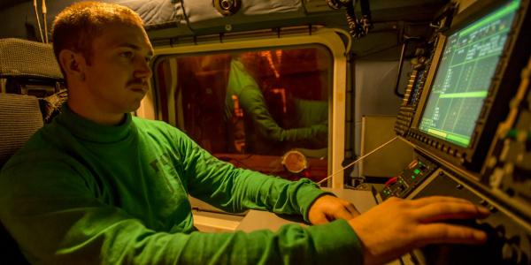 An aviation electronics technician first class performs maintenance on a mission computer aboard an MH-60R Seahawk helicopter on an aircraft carrier. The U.S. Navy seeks better computer and information systems for faster upgrades and less vulnerability to cybermarauders. 