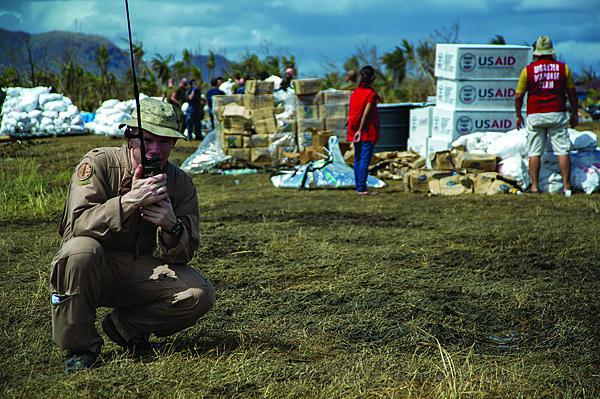 A U.S. Navy officer communicates with the USS George Washington to coordinate airlift operations during Operation Damayan, the relief effort following the devastating Philippine typhoon in November 2013. Prepositioned equipment and early entry communications gear proved invaluable to rapid disaster relief in the stricken area.