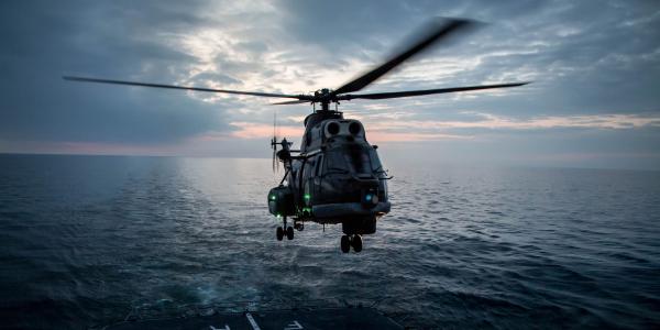A Romanian navy helicopter prepares to land on the deck of a frigate during maneuvers by Standing NATO Maritime Group 2 in the Black Sea. The NATO Communications and Information (NCI) Agency is looking toward industry to equip its military and organizational forces with proven technologies that enhance mobile links.
