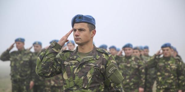 Romanian soldiers at a Romanian air base render honors with U.S. forces commemorating the 74th anniversary of the 1941 attack on Pearl Harbor. Romania’s growing activities with fellow NATO members include greater information sharing on cyberspace.