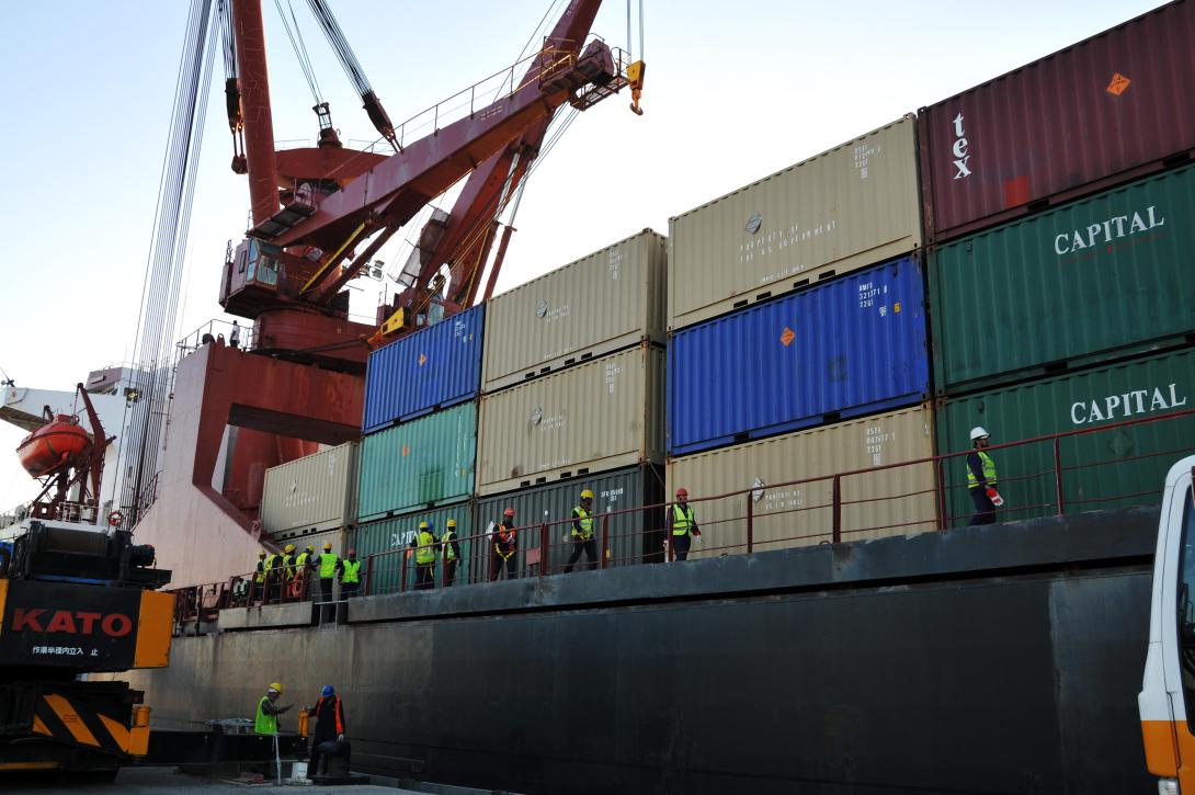 Workers prepare to offload shipping containers from a U.S. Military Sealift Command ship in Kuwait. Foreign cyber intrusions into commercial shipping networks have allowed cybermarauders access to significant information about cargoes and schedules.