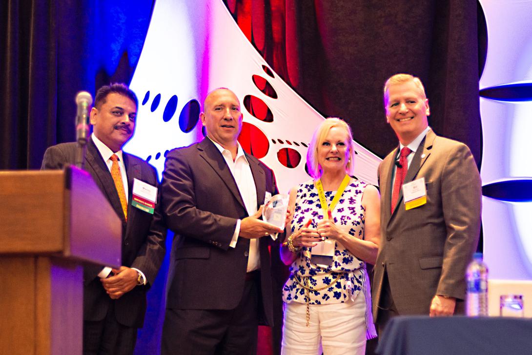 Tom Miller, CEO of Clearforce (2nd from l), receives the award for winning the final shark tank competition at the AFCEA Small Business Innovation Summit held July 26. Presenting the award to Tom are (l-r) Manoj Bhatia, president, Network Runners; Barbara Bridges, president, Empower Cyber; and Bill James, acting principal deputy assistant, Office of Information and Technology, U.S. Department of Veterans Affairs. Photography: Elizabeth Moon