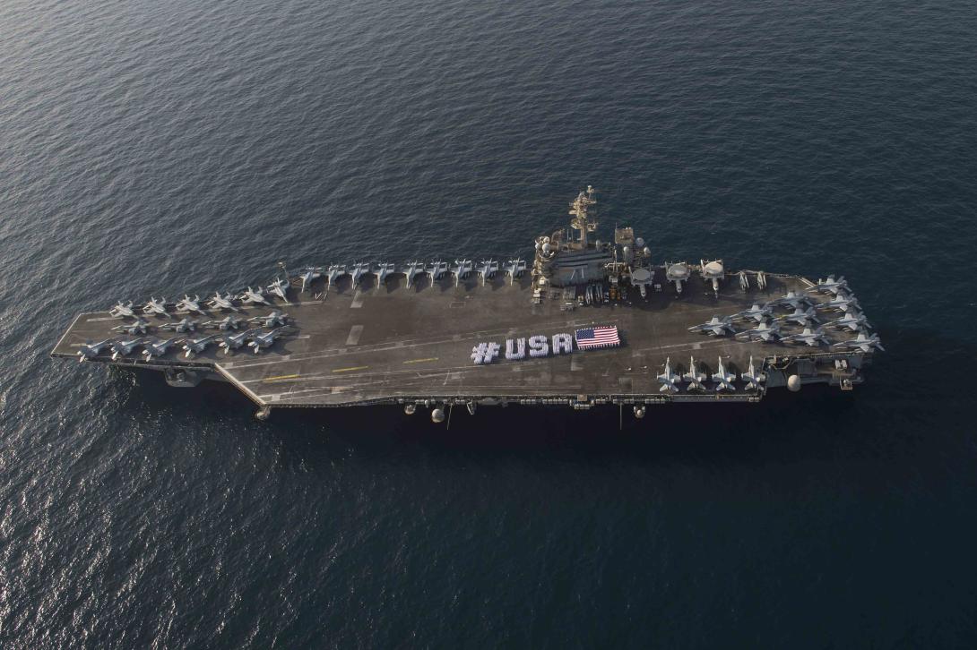 U.S. sailors spell out #USA on the flight deck of the aircraft carrier USS Theodore Roosevelt to observe Independence Day while deployed last year to the U.S. 5th Fleet area of operations supporting strike operations in Iraq and Syria. The NGA ship rider program inspired officials to expand the effort and will place analysts on a second aircraft carrier and large deck amphibious assault ships where intelligence teams tend to operate.