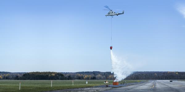 The unmanned version of Kaman Corporation’s K-MAX platform demonstrates dropping water on a controlled fire during trials at Griffiss Air Force Base in New York.