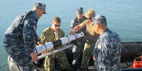 Croatian divers and U.S. sailors with Explosive Ordnance Disposal Mobile Unit (EODMU) 8 load an Iver 3 autonomous underwater vehicle (AUV) into the MK-5 Zodiac for testing.