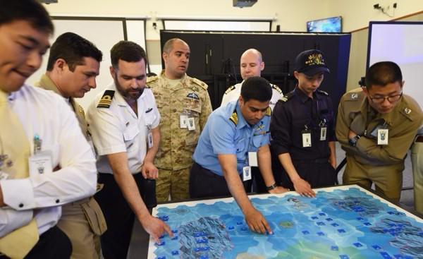 Coalition members engage in a war game exercise in 2015 at the U.S. Naval War College in Newport, Rhode Island. The students, 66 naval officers from 48 countries, were divided into teams and tasked with securing the fictitious “Green Island” during the exercise.