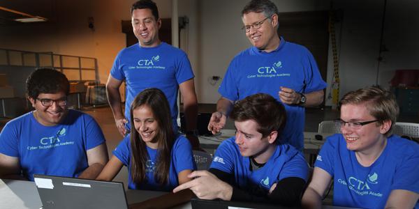 Led by Sandia National Laboratories instructors (top row, from l) C.W. Perr and Steve Hurd, students (bottom row, from l) Anuj Kak, Samantha MacIlwaine, Makena Harmon and Evan Laufer participate in hands-on training exercises as part of Sandia’s annual summer Cyber Technologies Academy. 