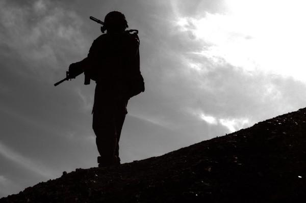 A U.S. Army soldier with the 101st Airborne Division (Air Assault) pauses before ascending a ridgeline near the Afghan village of Kote Khel.