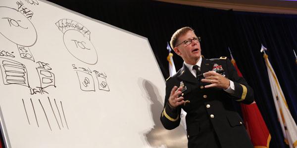 Maj. Gen. Stephen Fogarty, USA, commanding general of the U.S. Army Cyber Center of Excellence at Fort Gordon, Georgia, takes to the whiteboard to illustrate dysfunctional stovepipes that keep military disciplines from sharing information and missions.