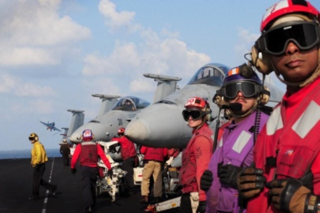 Sailors stand by while an F/A-18 Hornet launches from the flight deck of Nimitz-class aircraft carrier USS Dwight D. Eisenhower in 2012. The Navy’s use of modular open architecture solutions allows the service to bring rapid updates to legacy platforms, including as part of its F/A-18 Distributed Targeted Processor-Networked effort.  U.S. Navy photo by Mass Communication Specialist Seaman Sabrina Fine