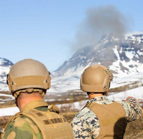 A U.S. Marine explosive ordnance disposal technician with Marine Rotational Force-Europe 20.2, Marine Forces Europe and Africa (l) and a Norwegian soldier (r) overlook an explosion of safely detonated high-explosives found during a sweep in Setermoen, Norway, in June.  USMC photo by Lance Cpl. Chase Drayer