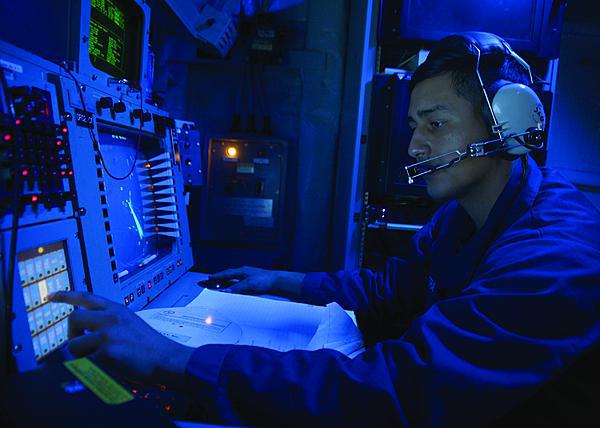 A U.S. Navy cryptologic technician monitors the electromagnetic spectrum of air and surface contacts in the combat information center aboard the guided-missile destroyer USS Ramage.