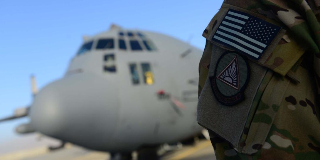 An airman from the 41st Expeditionary Electronic Combat Squadron stands next to an EC-130H Compass Call aircraft in September 2014 at Bagram Air Base, Afghanistan. The squadron provides counter-communications electronic attack capabilities.