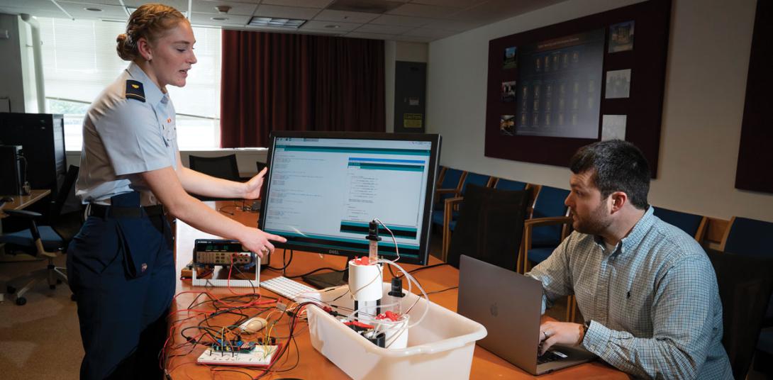 Hollis Roush, a Coast Guard Cadet intern at the Massachusetts Institute of Technology Lincoln Laboratories (MITLL), demonstrates a prototype representative industrial control system. Credit: Glen Cooper, MIT Lincoln Laboratory