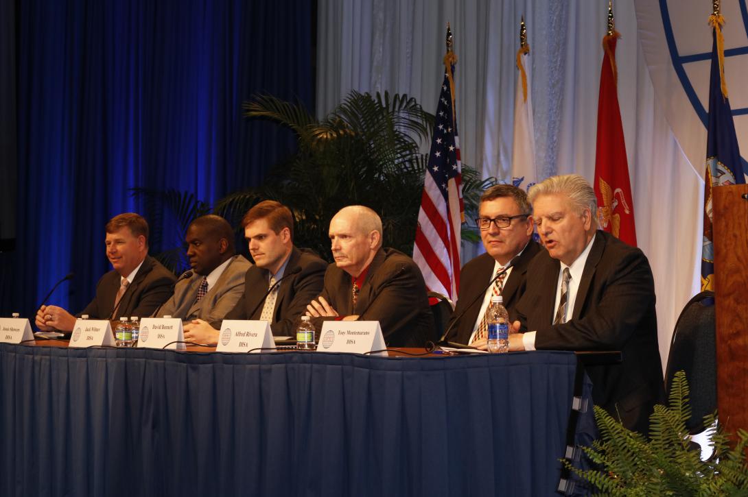 Tony Montemarano (r) moderates a panel of DISA officials (l-r): Jack Wilmer, infrastructure development executive; Jessie Showers, infrastructure executive; Alfred Rivera, director, Development and Business Center; John Hickey Jr., risk management executive and CIO; and David Bennett, director, Implementation and Sustainment Center.