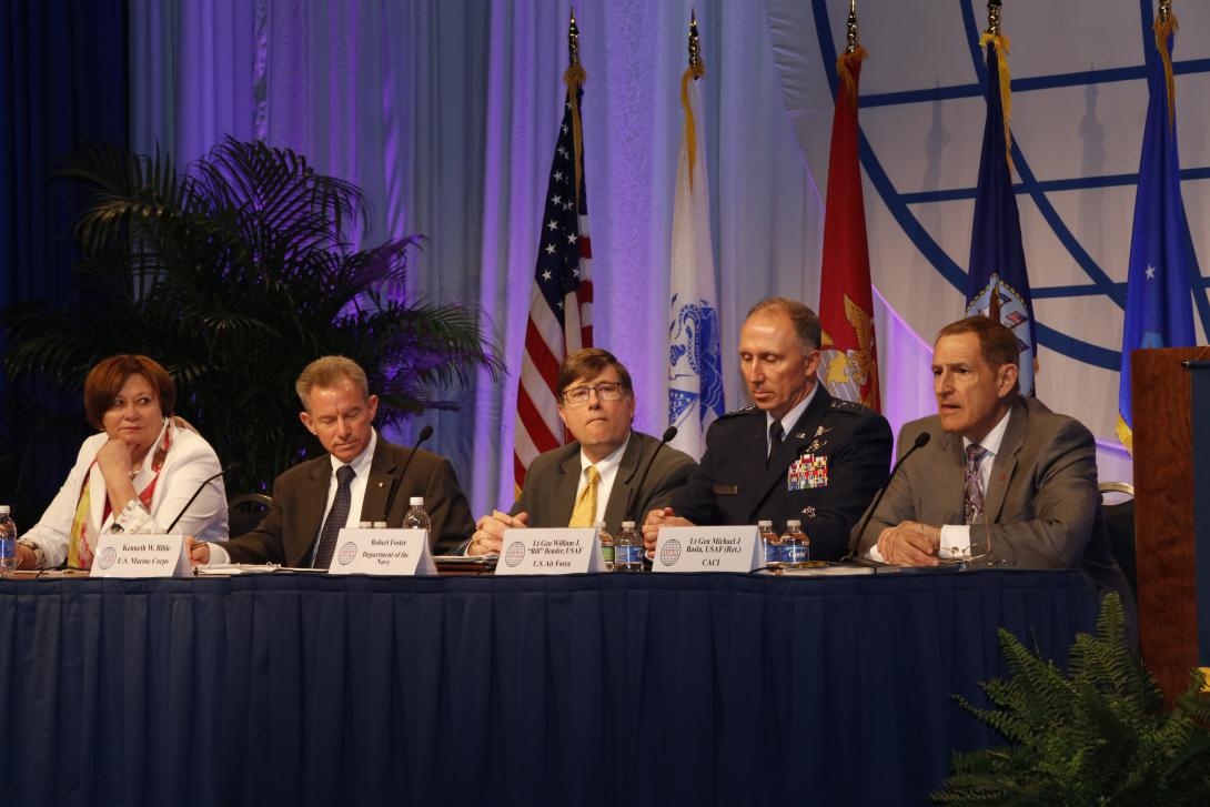 Lt. Gen. Mike Basla, USAF (Ret.), of CACI (r), leads a panel of current and former service CIOs and deputies: (r-l) Lt. Gen. William J. Bender, USAF, Air Force CIO; Robert Foster, Navy CIO; Ken Bible, Marine Corps deputy CIO; and Lt. Gen. Susan Lawrence, USA (Ret.), of Booz Allen Hamilton, former Army CIO.
