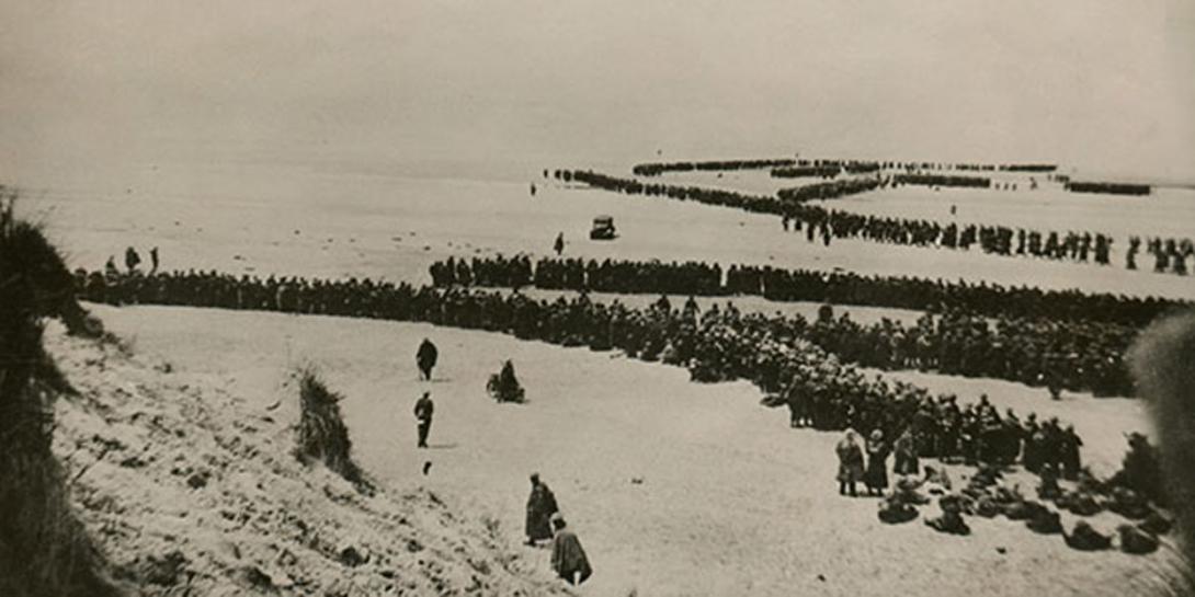 Thousands of British and French troops wait on the dunes of Dunkirk Beach, France, for transport to England during World War II, between May 26 and June 4, 1940. The Central Intelligence Agency cites the military evacuation of Dunkirk as the time its predecessor agency started depending on the private sector for key strategic intelligence. Credit: Shutterstock/Everett Historical