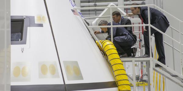 Kennedy Space Center Director Bob Cabana (l); John Mulholland, vice president and program manager of Boeing Commercial Programs (c); and Jorge Hernandez, president of Bastion Technologies, examine a Boeing CST-100 Starliner mock-up in the Kennedy Space Center’s former Orbiter Processing Facility 3.