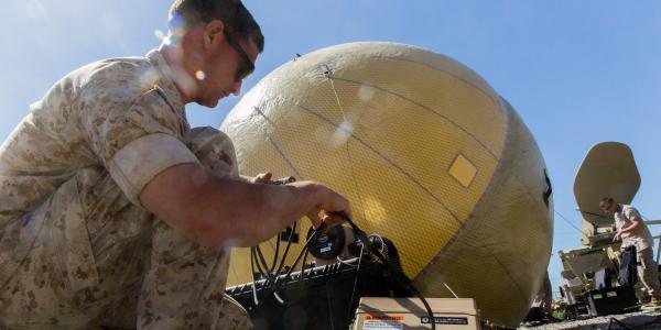 A satellite communications operator with the 11th Marine Expeditionary Unit (MEU) adjusts a 1.8-meter inflatable satellite communications dish during an exercise at Marine Corps Base Camp Pendleton, California. As the Marines augment the 11th MEU, their goal during the exercise was to standardize operating procedures and maintain functional command networks to prepare for MEU deployments.