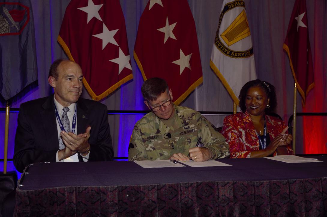 Gen. Fogarty (c) signs the paperwork to initiate a new civilian cyber career program. Ronald W. Pontius, deputy to the commanding general, U.S. Army Cyber Command, and Andricka Thomas, CP-71 director, join him during the signing. Photo by Michael Carpenter